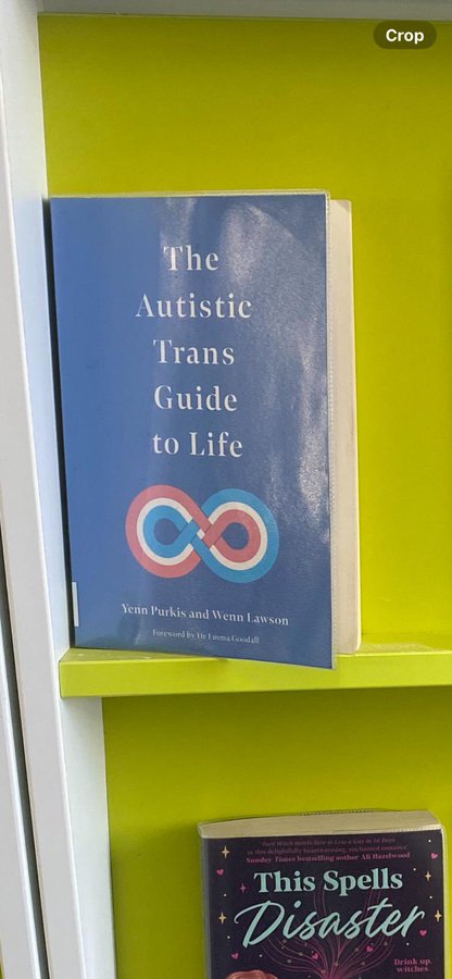 "The Autistic Trans Guide to Life" on a bookshelf